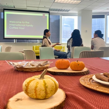 People gathered around a table talking with cookies in the foreground.