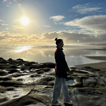 Clara Oh walking along the shore