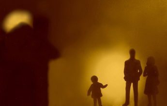 Shadow figures of a child and parents.