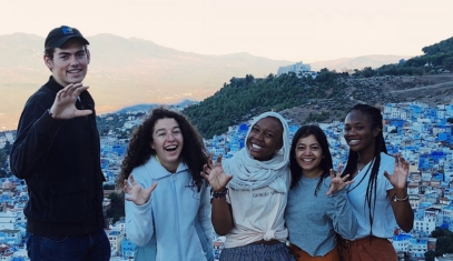 A group of students on a cliff above a city