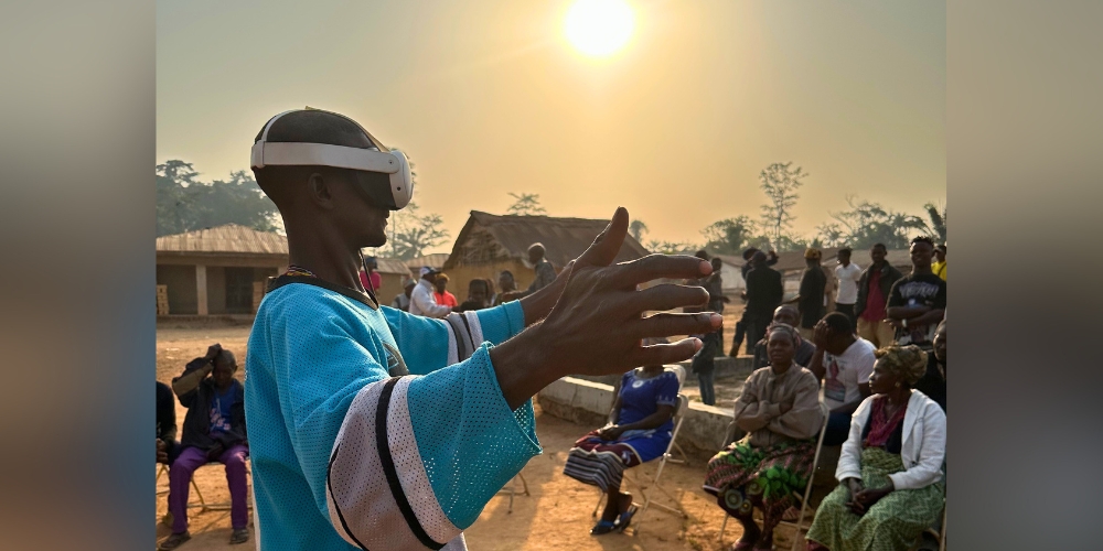 Chief Arthur Saygbah stretches his hands as he analyzes a Loma mask from the Brooklyn Museum via a VR headset. (Selega, Liberia)
