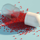 A broken pill spills out tiny beads