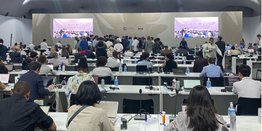 Country delegates are huddled in the center of the room ironing out language of a draft document