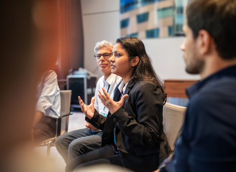 A young woman talking to a group of colleagues