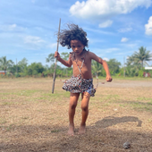 A young boy living in an Amazonian community performs a native dance. 