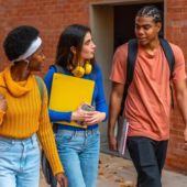 A group of students walking on a college campus.