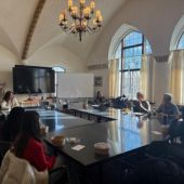 Students sit with disinformation experts around a large table for a chance to talk one on one.