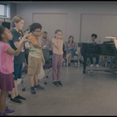Children practicing music and breathwork exercises with a teacher