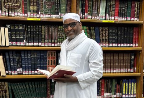 Buffett Faculty Fellow Zekeria Ahmed Salem in front of a library shelf