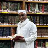 Buffett Faculty Fellow Zekeria Ahmed Salem in front of a library shelf