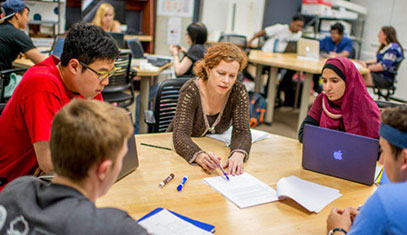students and instructor talking around a table