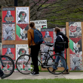 Signage all along an iron fence in support of Gaza outside an encampment at Northwestern University's Deering Meadow is seen on April 26, 2024.