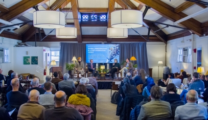 An audience watches a symposium panel at a Buffett event